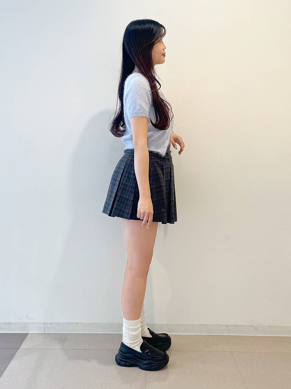 ブラック系のローファー、グレー系のスカート、レッド系のショルダーバッグを着用したレディースの春コーディネートの3枚目の写真