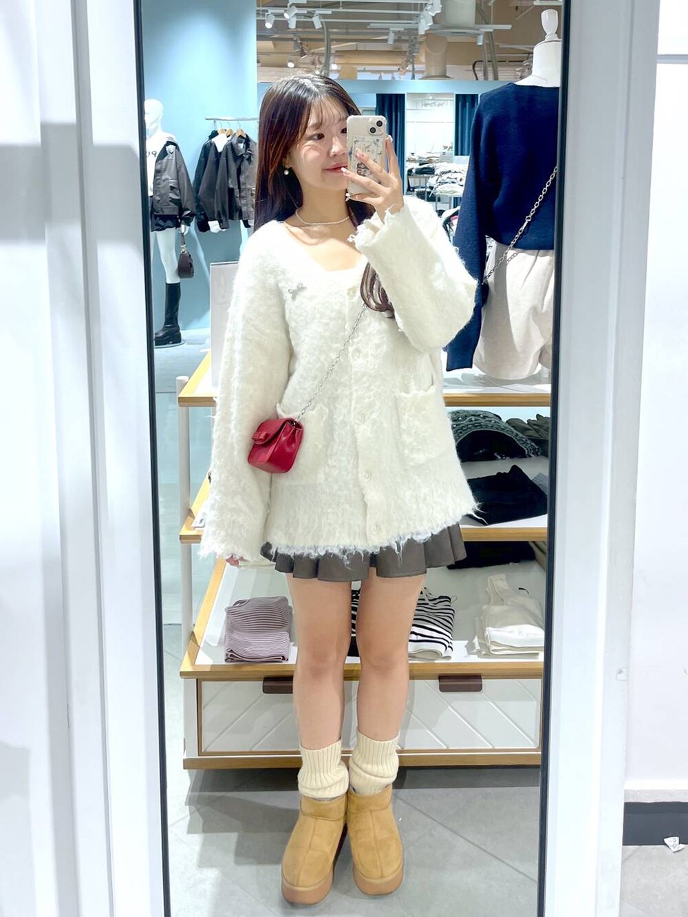 ブラウン系のスカート、ホワイト系のカーディガン/ボレロ、ベージュ系のブーツを着用したレディースの秋コーディネートの7枚目の写真