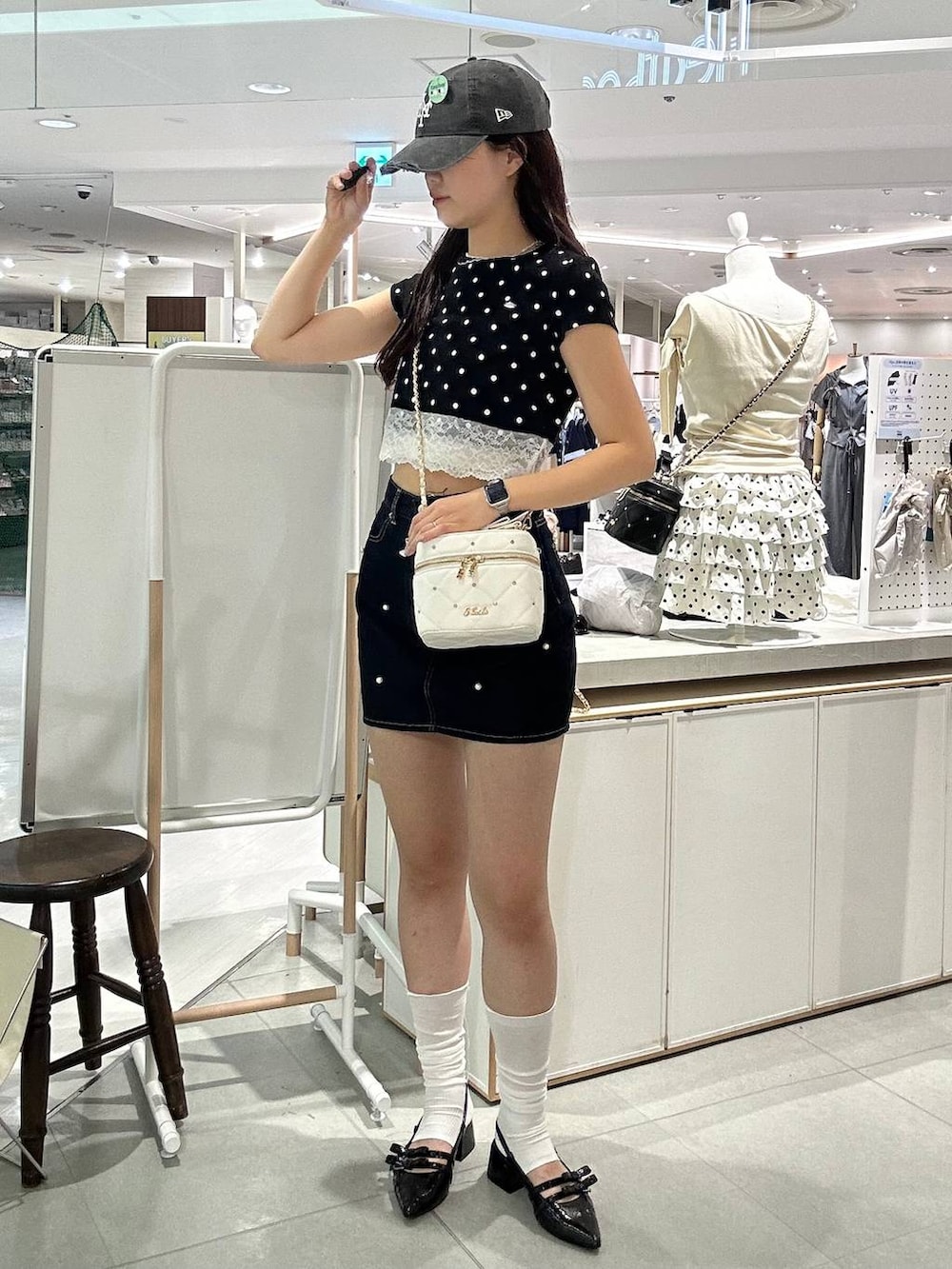 ホワイト系のショルダーバッグ、ブラック系のパンプス、ホワイト系のチューブトップを着用したレディースの夏コーディネートの5枚目の写真