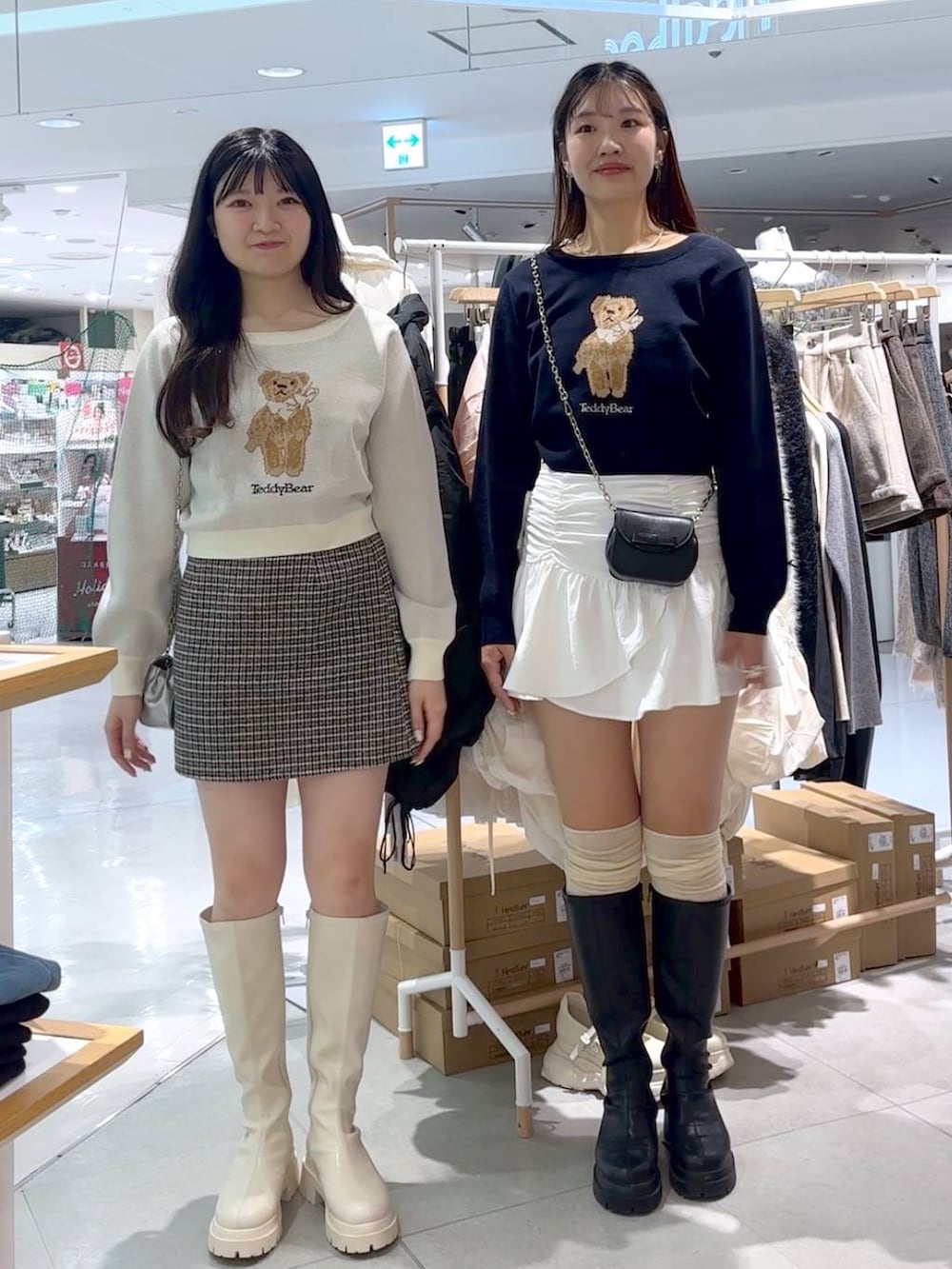 ブラック系のスカート、ブラック系のショルダーバッグ、ブラック系のブーツを着用したレディースの秋コーディネートの2枚目の写真