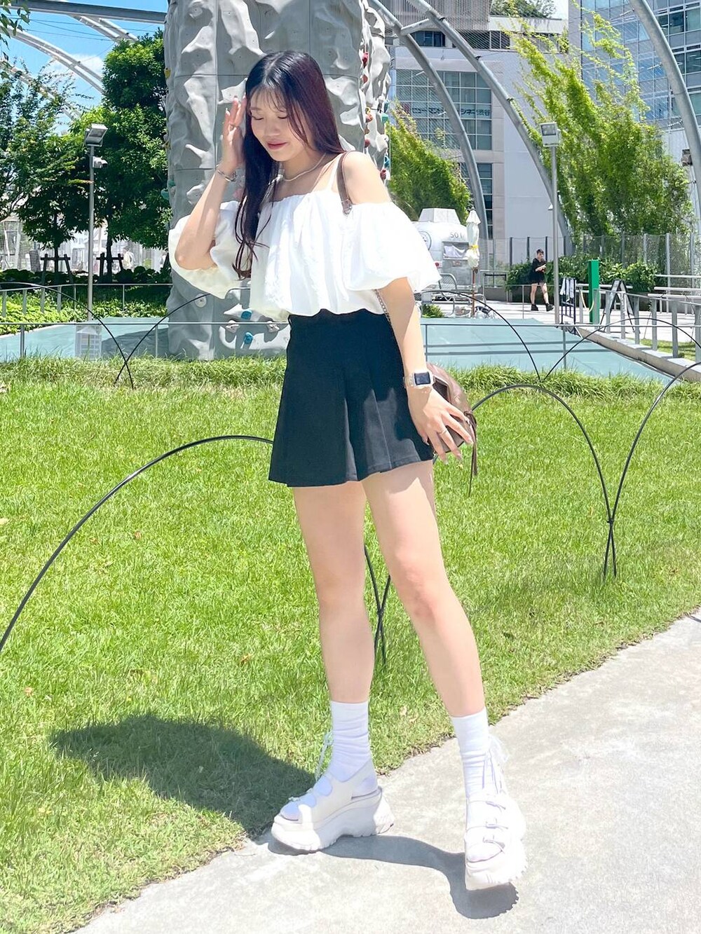 ブラック系のスカート、ホワイト系のシャツ/ブラウス、ホワイト系のキャミソールを着用したレディースの夏コーディネートの5枚目の写真