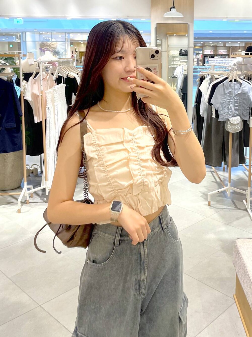 シルバー系のサンダル、ホワイト系のキャミソール、ブルー系のデニムパンツを着用したレディースの夏コーディネートの6枚目の写真