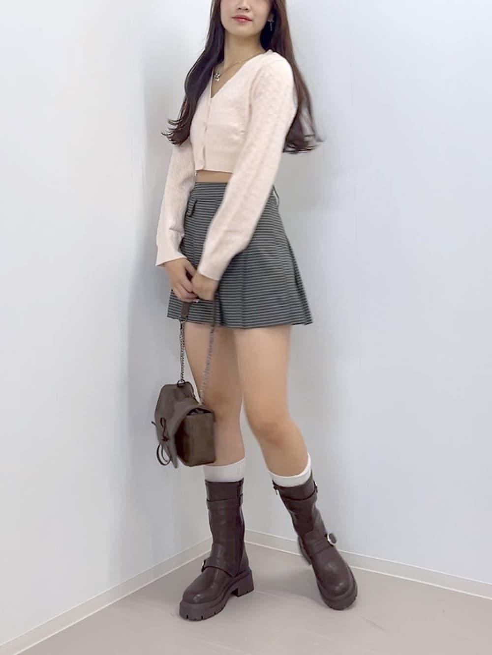 ブラウン系のショルダーバッグ、ブラウン系のブーツ、ホワイト系のキャミソールを着用したレディースの秋コーディネートの2枚目の写真