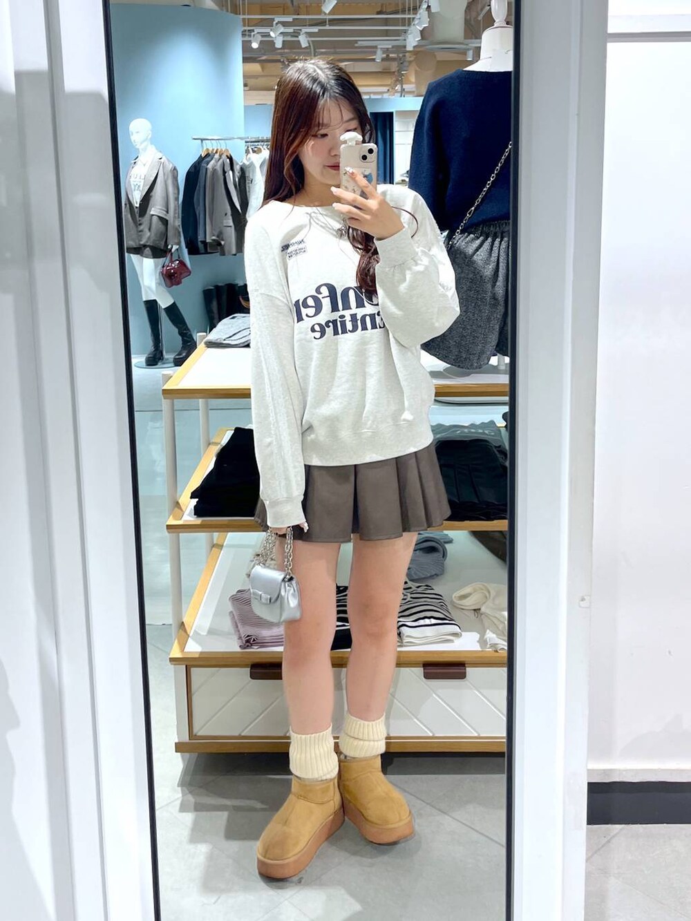 ホワイト系のTシャツ/カットソー、ブラウン系のスカート、ベージュ系のブーツを着用したレディースの秋コーディネートの10枚目の写真