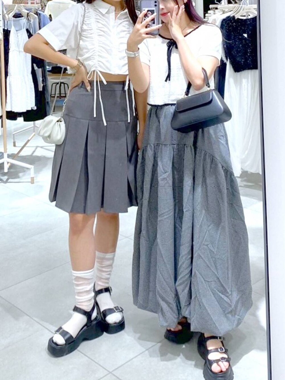 ブラック系のショルダーバッグ、ブラック系のサンダル、グレー系のスカートを着用したレディースの夏コーディネートの3枚目の写真