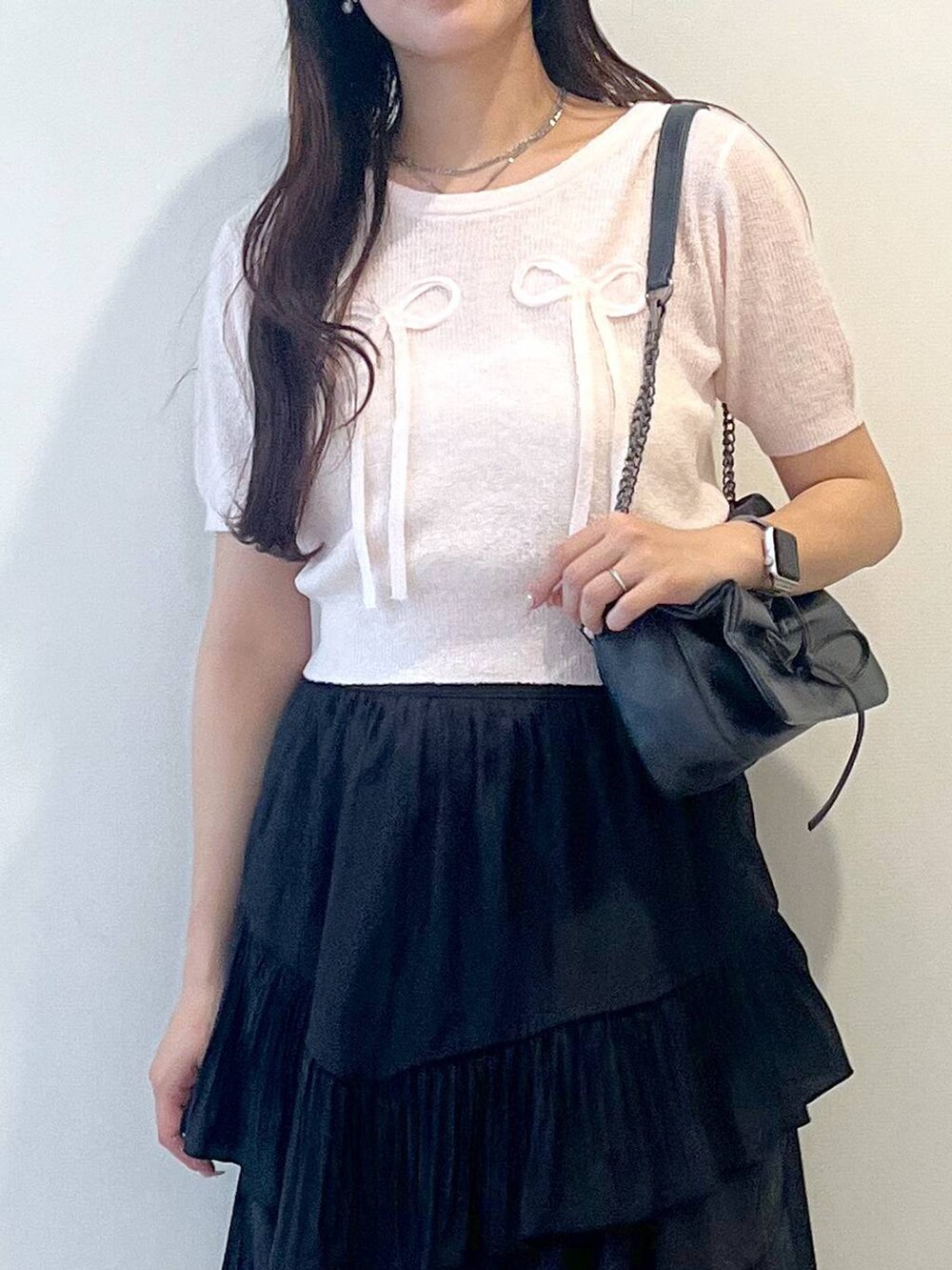 グレー系のショルダーバッグ、ホワイト系のキャミソール、ブラック系のスカートを着用したレディースの春コーディネートの9枚目の写真