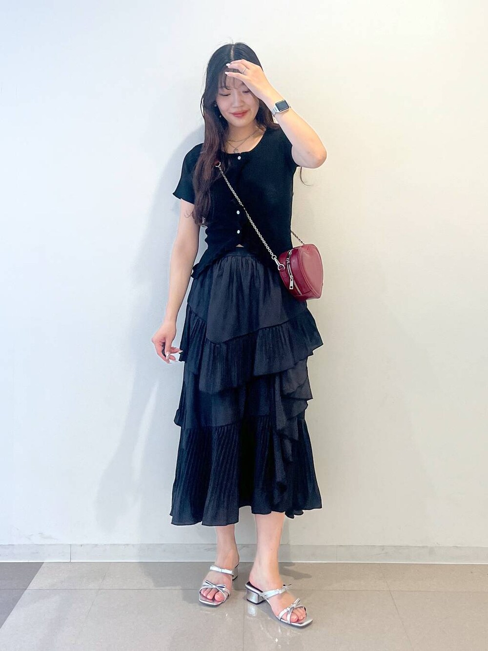 ホワイト系のキャミソール、ブラック系のスカート、シルバー系のサンダルを着用したレディースの春コーディネートの2枚目の写真