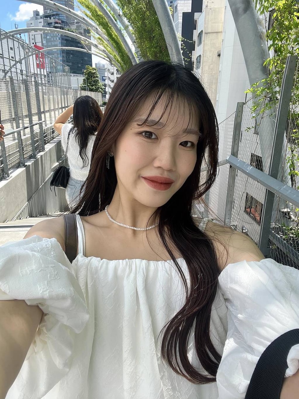 ブラック系のスカート、ホワイト系のシャツ/ブラウス、ホワイト系のキャミソールを着用したレディースの夏コーディネートの3枚目の写真