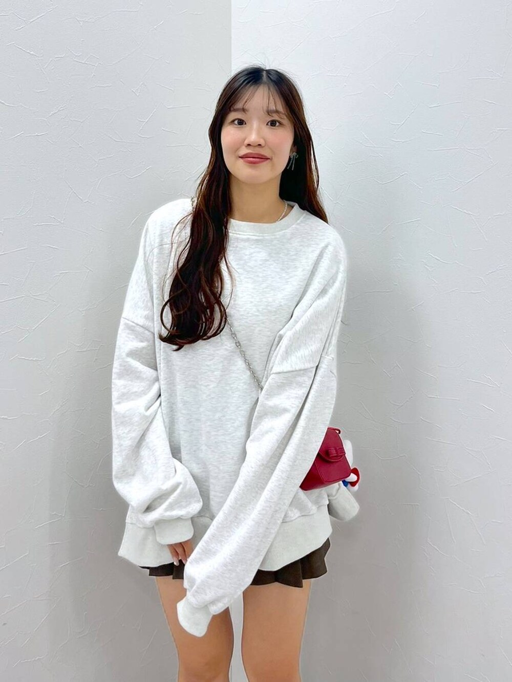 ホワイト系のTシャツ/カットソー、ブラウン系のスカート、レッド系のショルダーバッグを着用したレディースの秋コーディネートの4枚目の写真