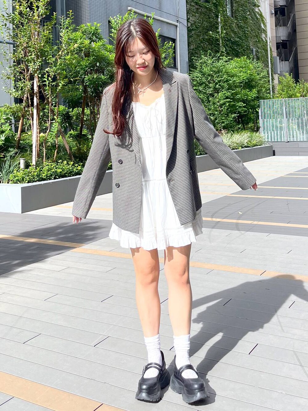 ホワイト系のキャミソール、ホワイト系のワンピース、ブラック系のスニーカーを着用したレディースの秋コーディネートの2枚目の写真