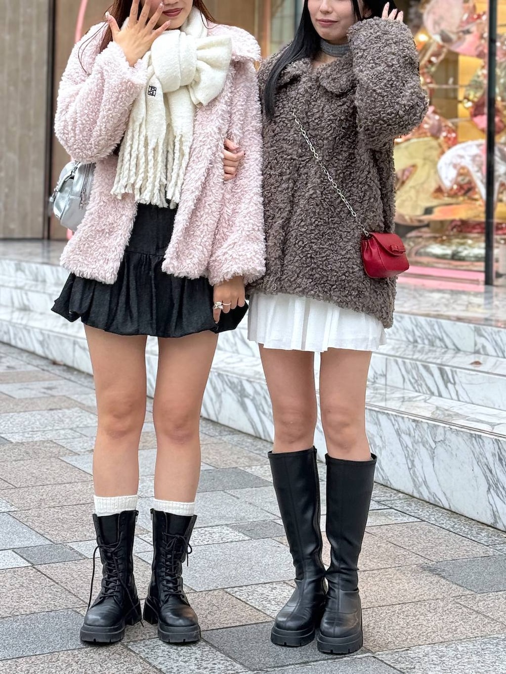 レッド系のショルダーバッグ、ブラック系のブーツ、ピンク系のステンカラーコートを着用したレディースの秋コーディネートの5枚目の写真