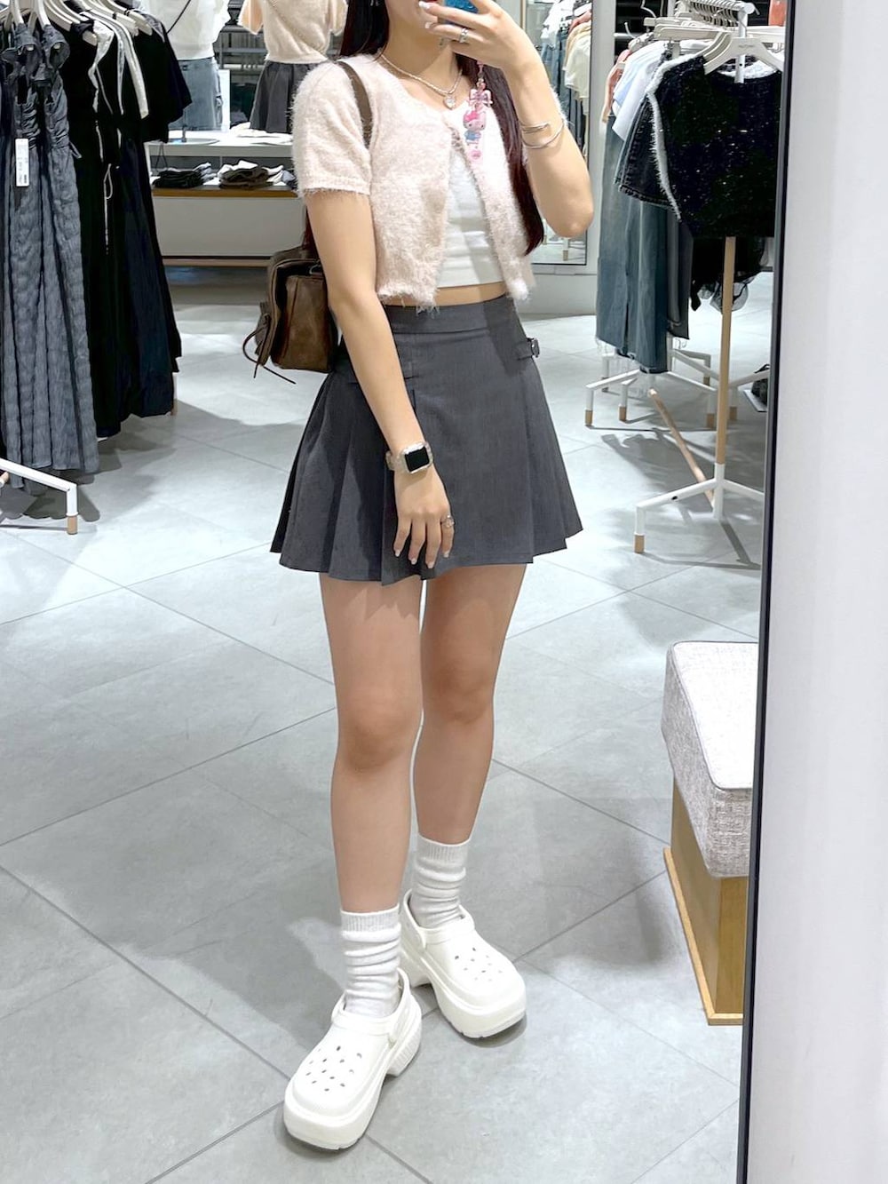 グレー系のスカート、ピンク系のカーディガン/ボレロ、ホワイト系のキャミソールを着用したレディースの夏コーディネートの5枚目の写真