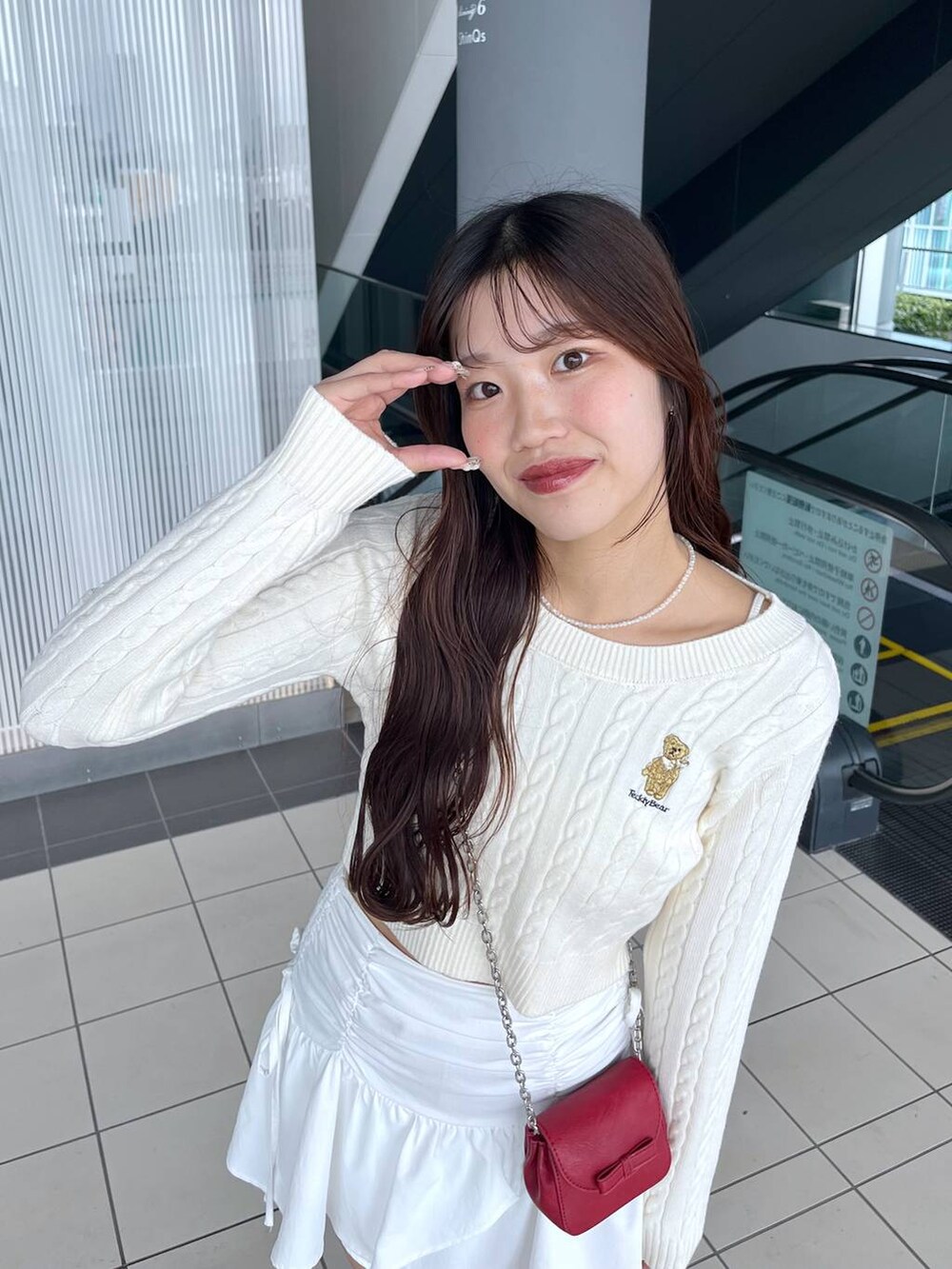 ホワイト系のTシャツ/カットソー、レッド系のショルダーバッグ、ホワイト系のブーツを着用したレディースの冬コーディネートの9枚目の写真