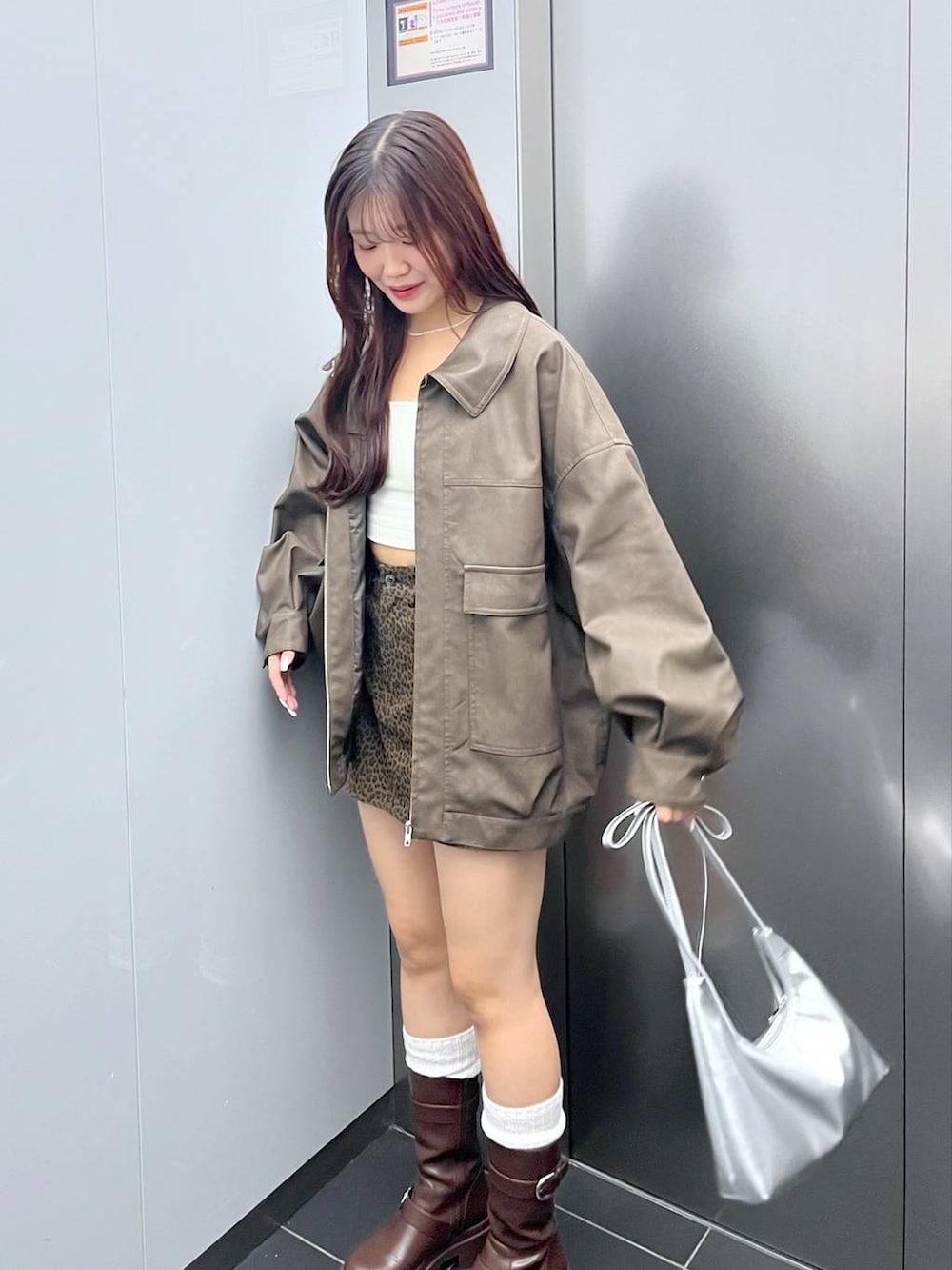 ブラウン系のブーツ、その他のスカート、シルバー系のショルダーバッグを着用したレディースの秋コーディネートの2枚目の写真