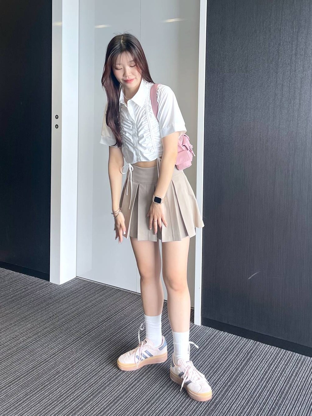 ピンク系のショルダーバッグ、ホワイト系のキャミソール、ベージュ系のスカートを着用したレディースの夏コーディネートの5枚目の写真