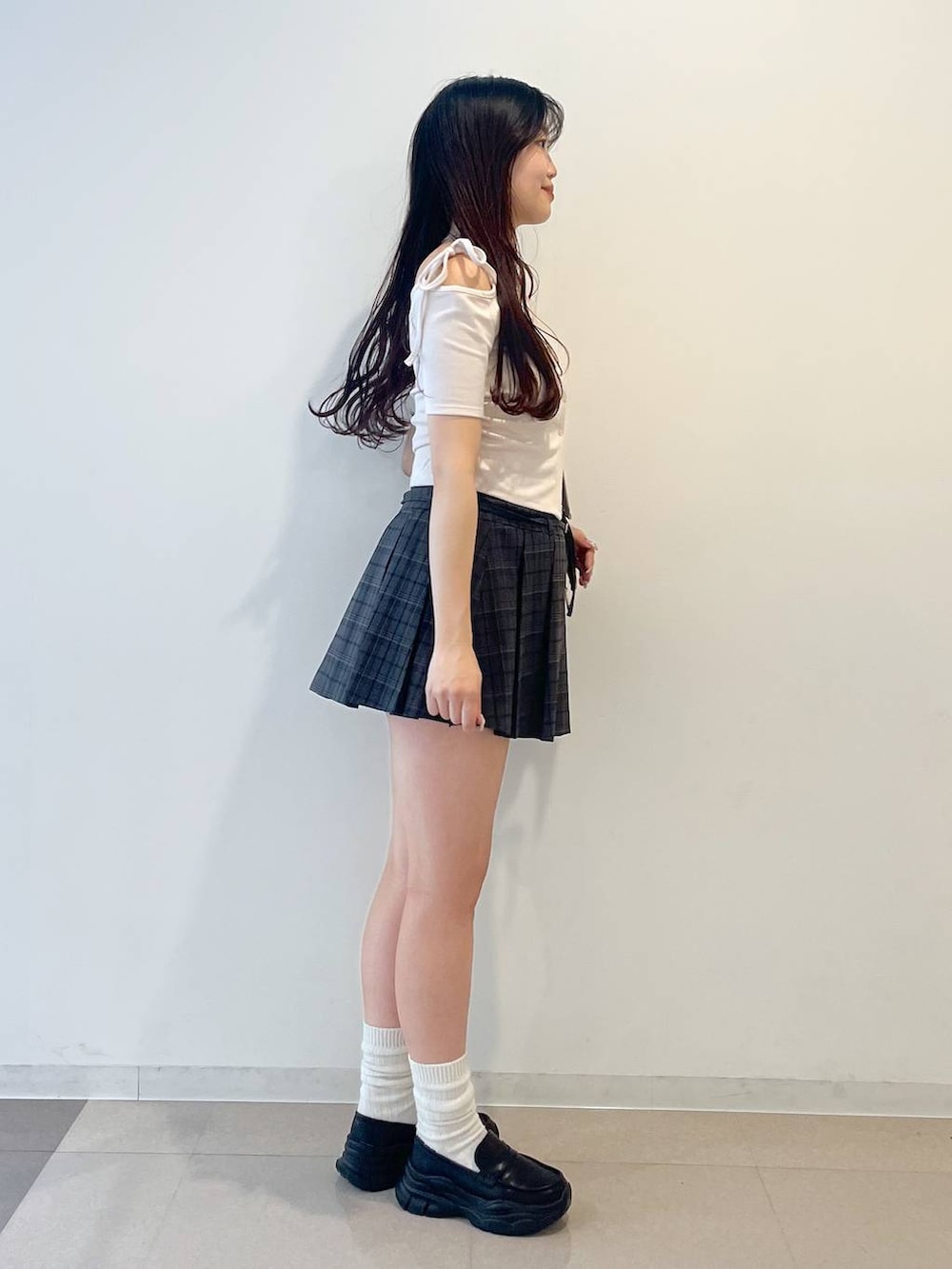 ブラック系のローファー、グレー系のスカート、レッド系のショルダーバッグを着用したレディースの春コーディネートの2枚目の写真