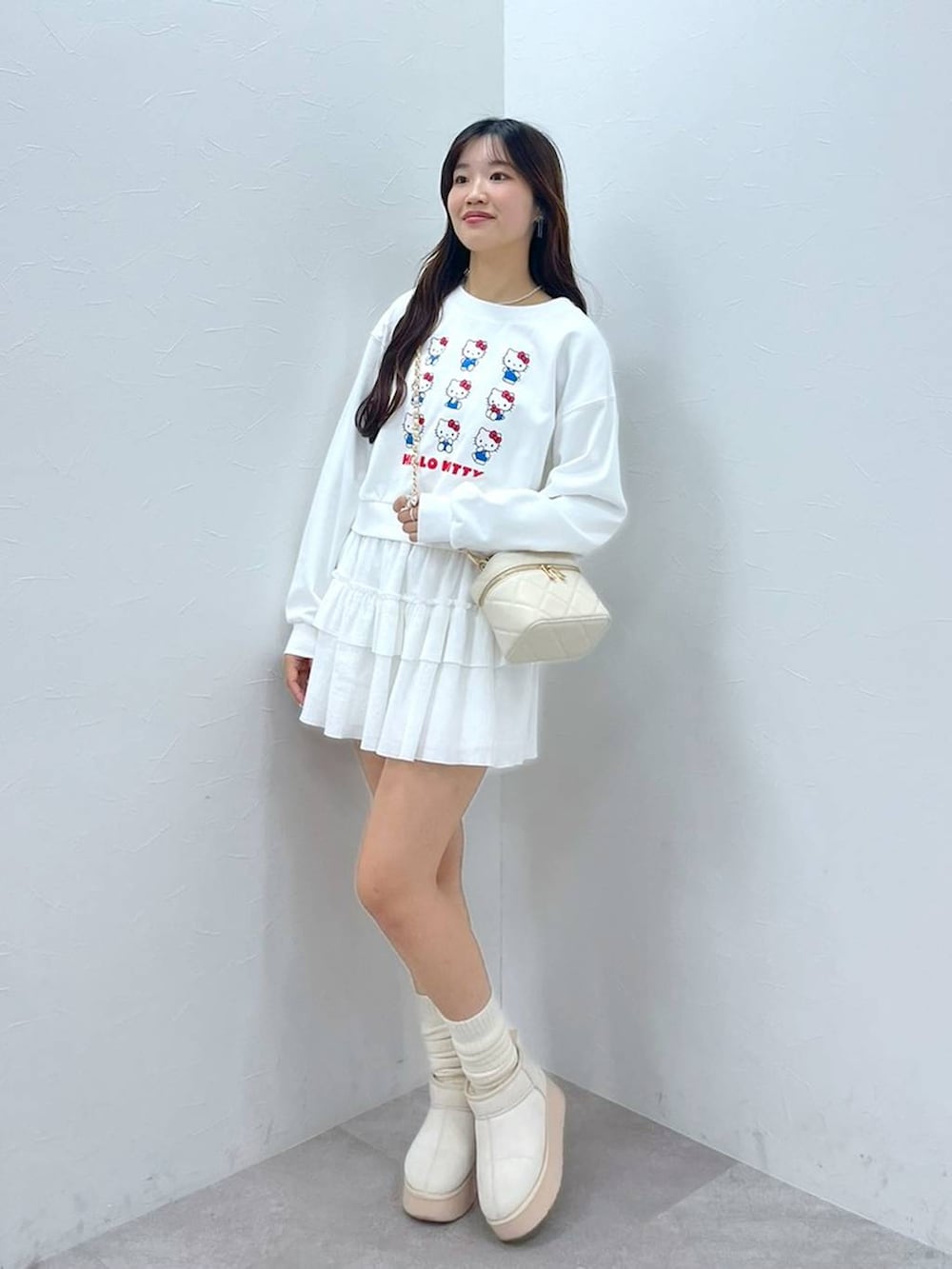 ホワイト系のTシャツ/カットソー、ホワイト系のショルダーバッグ、ホワイト系のブーツを着用したレディースの秋コーディネートの2枚目の写真