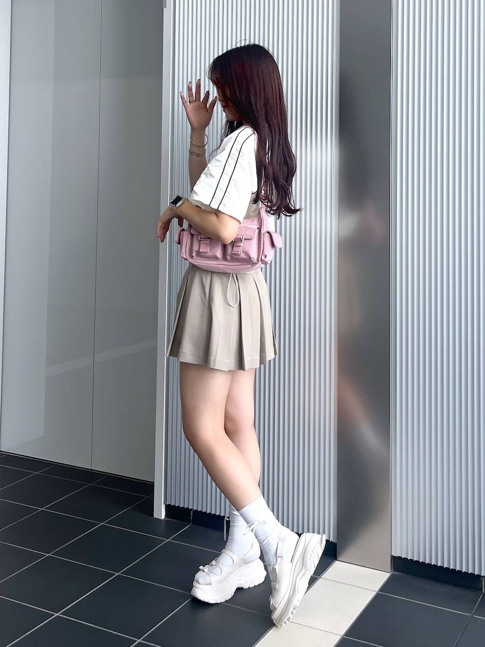 ピンク系のショルダーバッグ、ホワイト系のキャミソール、ホワイト系のサンダルを着用したレディースの夏コーディネートの3枚目の写真