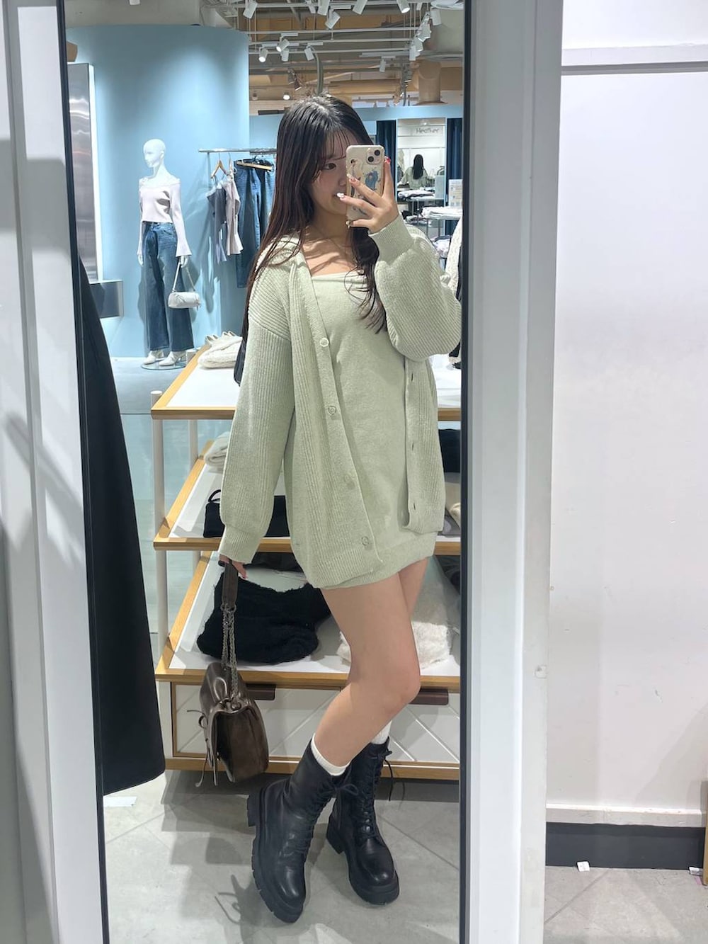 ブラック系のショルダーバッグ、ブラック系のブーツ、ホワイト系のTシャツ/カットソーを着用したレディースの冬コーディネートの3枚目の写真