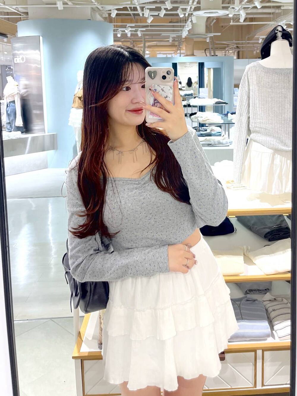 ブラウン系のショルダーバッグ、ホワイト系のキャミソール、ブラック系のブーツを着用したレディースの春コーディネートの2枚目の写真