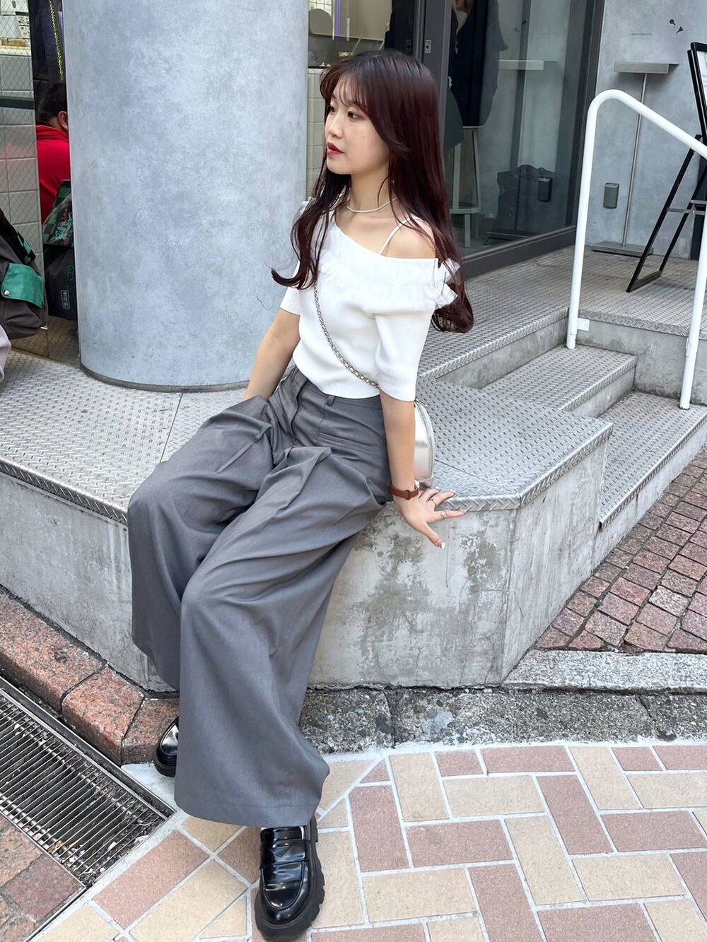 シルバー系のショルダーバッグ、グレー系のスラックス、ホワイト系のキャミソールを着用したレディースの春コーディネートの4枚目の写真