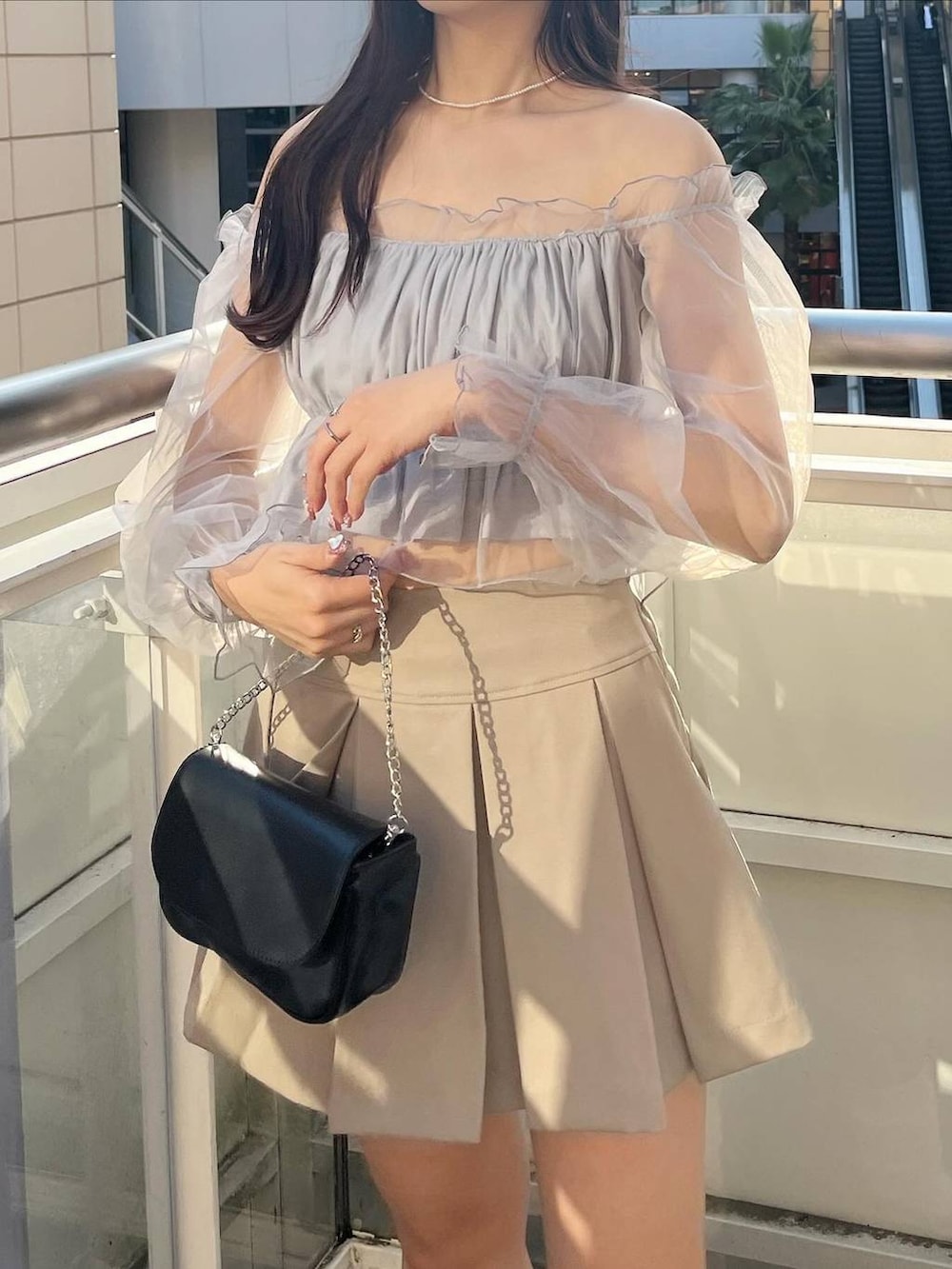 ブラック系のショルダーバッグ、グレー系のシャツ/ブラウス、ホワイト系のキャミソールを着用したレディースの春コーディネートの4枚目の写真