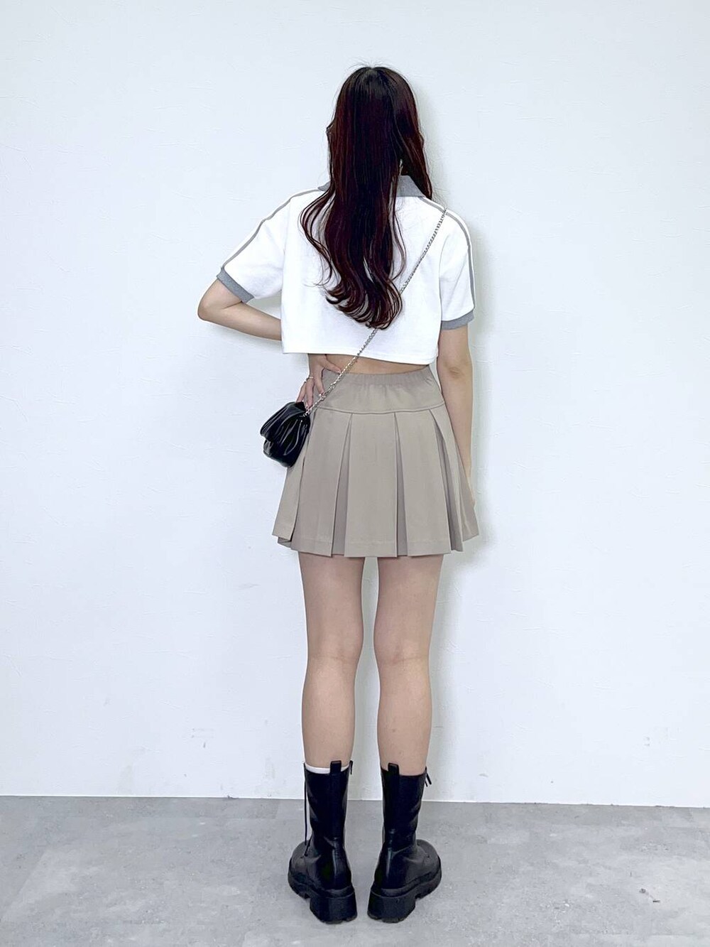 ブラック系のショルダーバッグ、ブラック系のブーツ、ホワイト系のキャミソールを着用したレディースの夏コーディネートの3枚目の写真