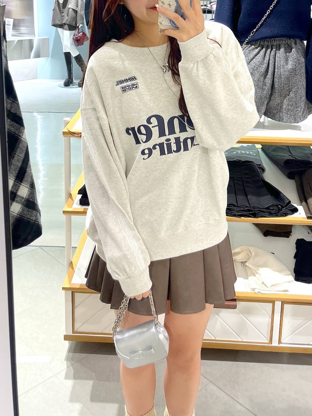 ホワイト系のTシャツ/カットソー、ブラウン系のスカート、ベージュ系のブーツを着用したレディースの冬コーディネートの5枚目の写真