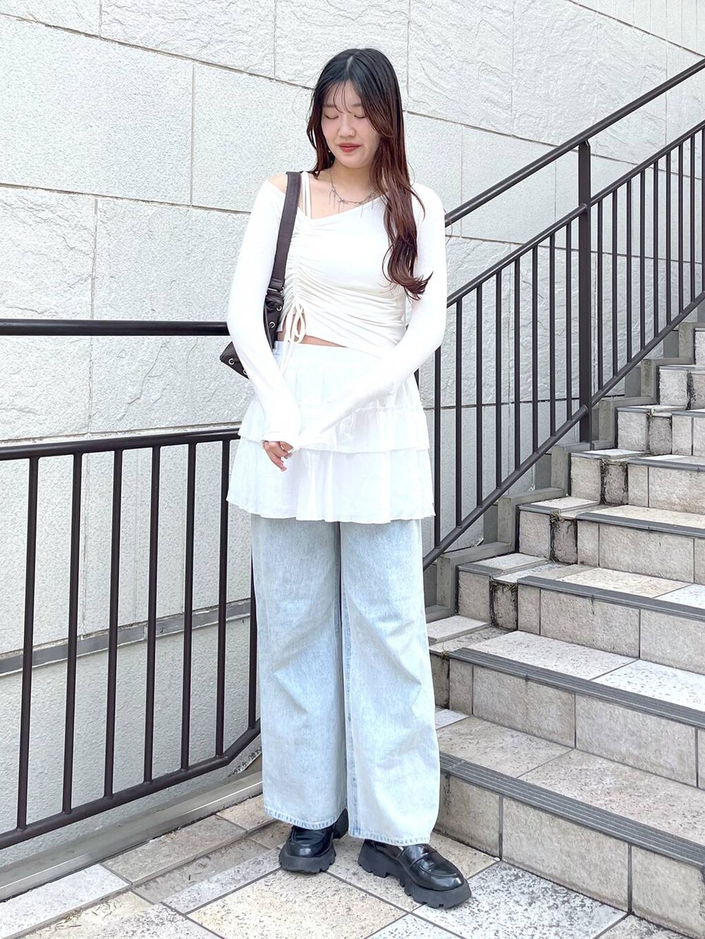 ホワイト系のキャミソール、ブルー系のデニムパンツ、ホワイト系のスカートを着用したレディースの春コーディネートの5枚目の写真