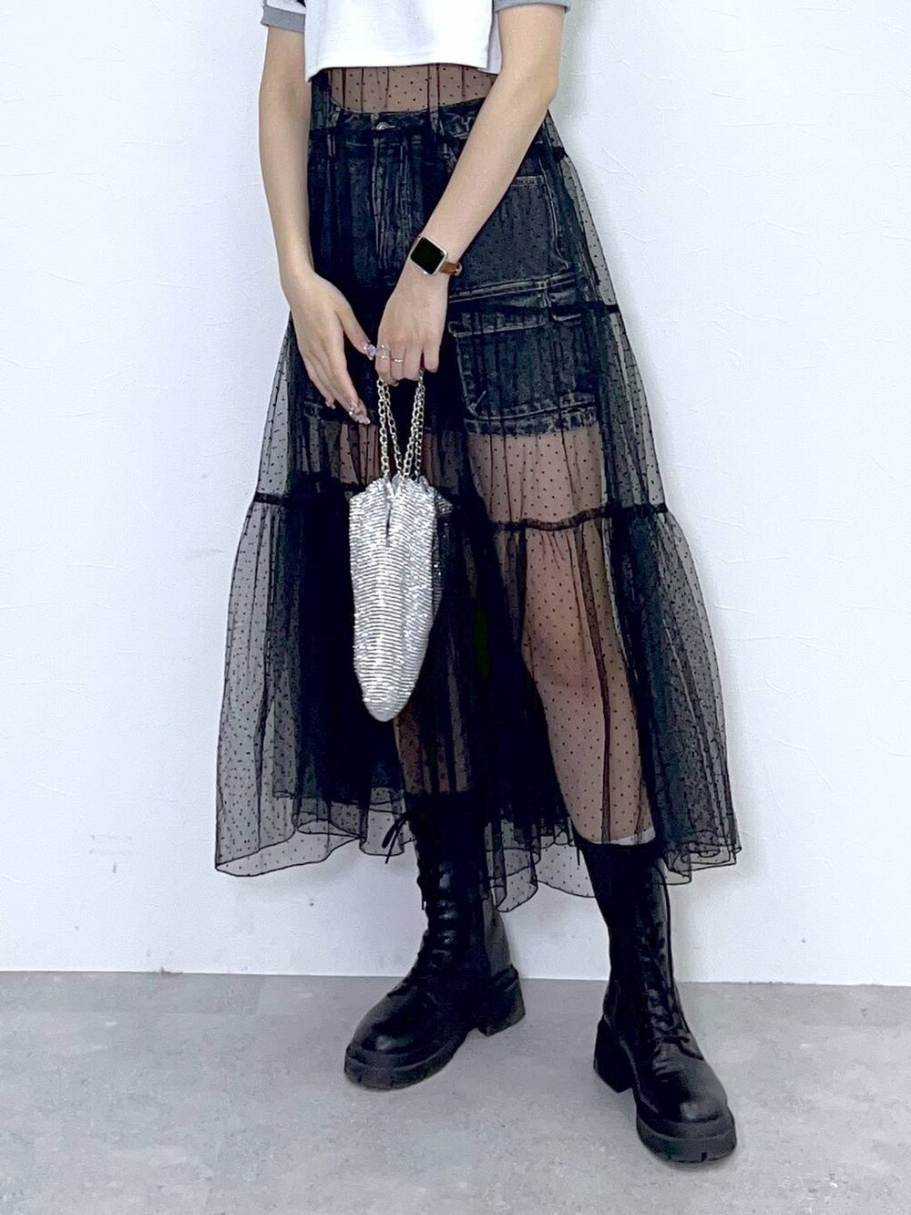 ブラック系のワンピース、ブラック系のブーツ、ブラック系のデニムスカートを着用したレディースの春コーディネートの5枚目の写真