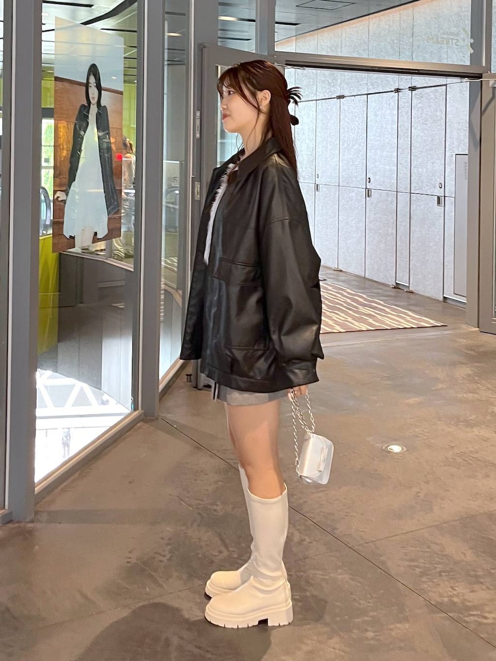 グレー系のスカート、ブルー系のカーディガン/ボレロ、ホワイト系のブーツを着用したレディースの秋コーディネートの5枚目の写真