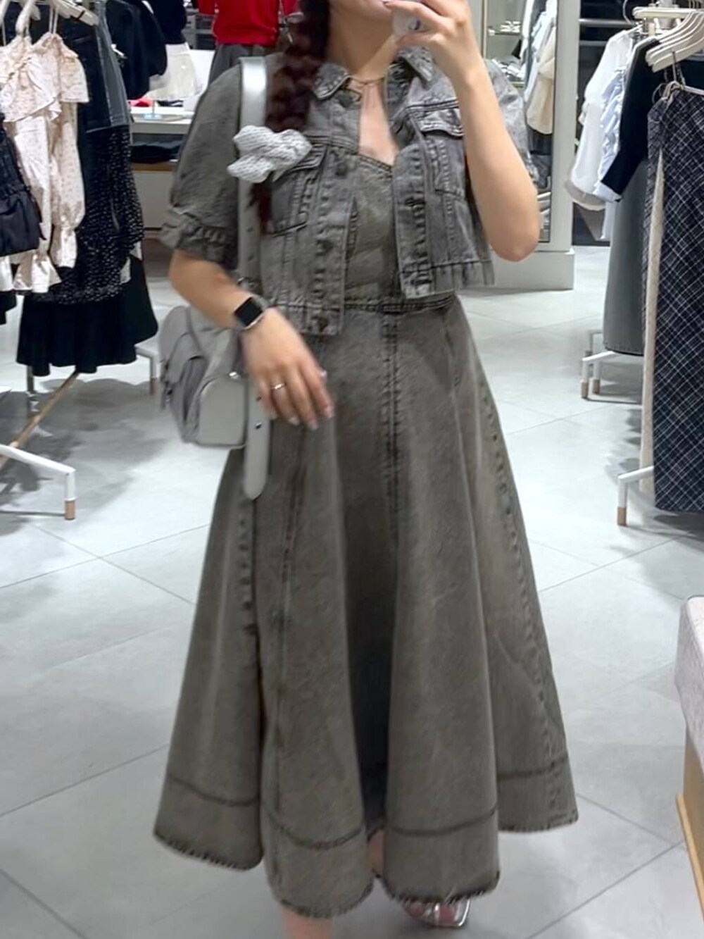 シルバー系のショルダーバッグ、グレー系のデニムジャケット、グレー系のワンピースを着用したレディースの春コーディネートの5枚目の写真