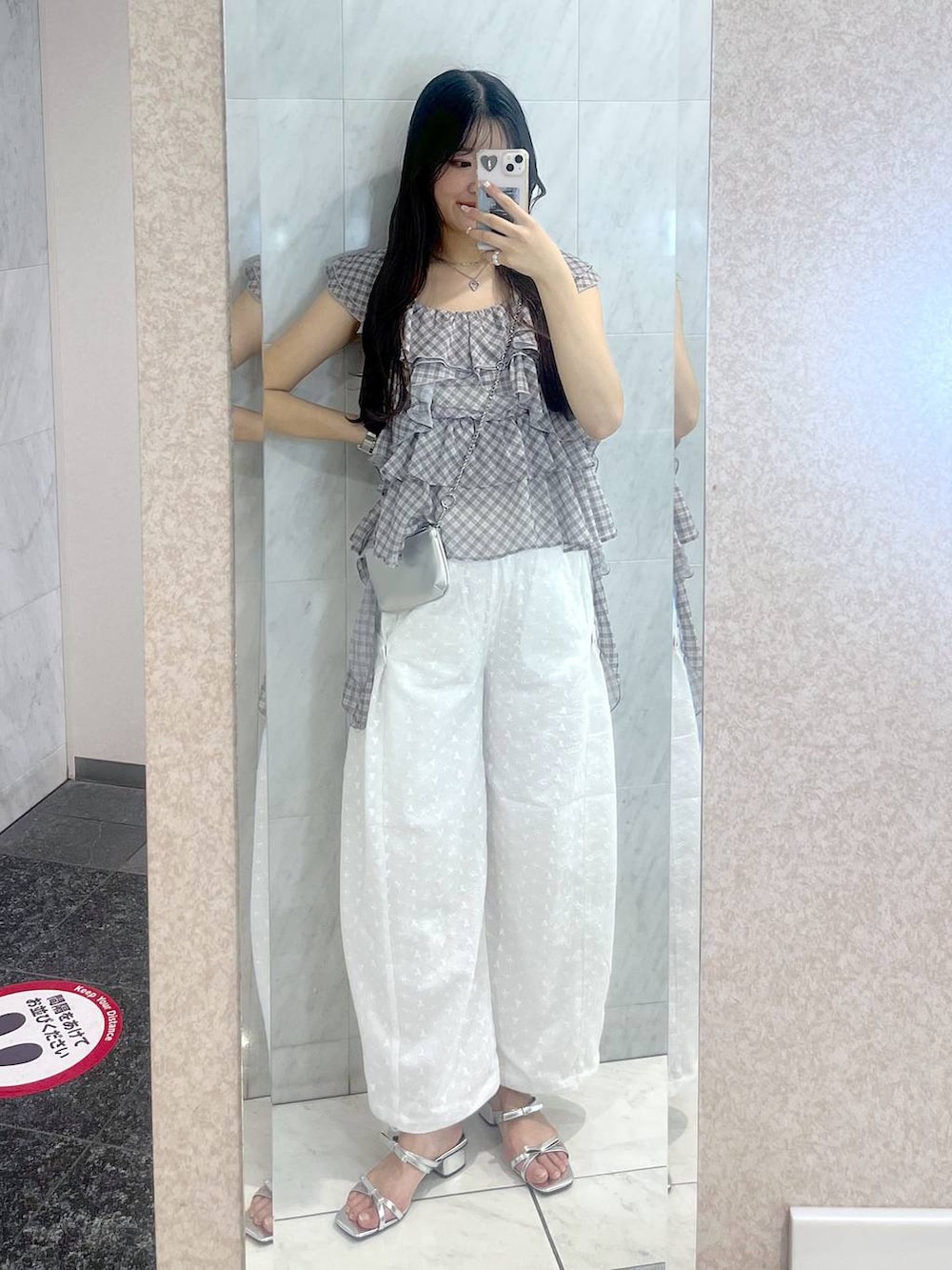 ホワイト系のキャミソール、シルバー系のサンダル、シルバー系のショルダーバッグを着用したレディースの夏コーディネートの3枚目の写真