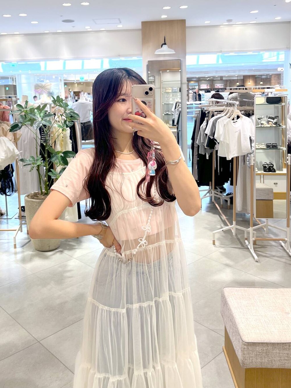 ホワイト系のワンピース、ピンク系のTシャツ/カットソー、シルバー系のサンダルを着用したレディースの春コーディネートの2枚目の写真