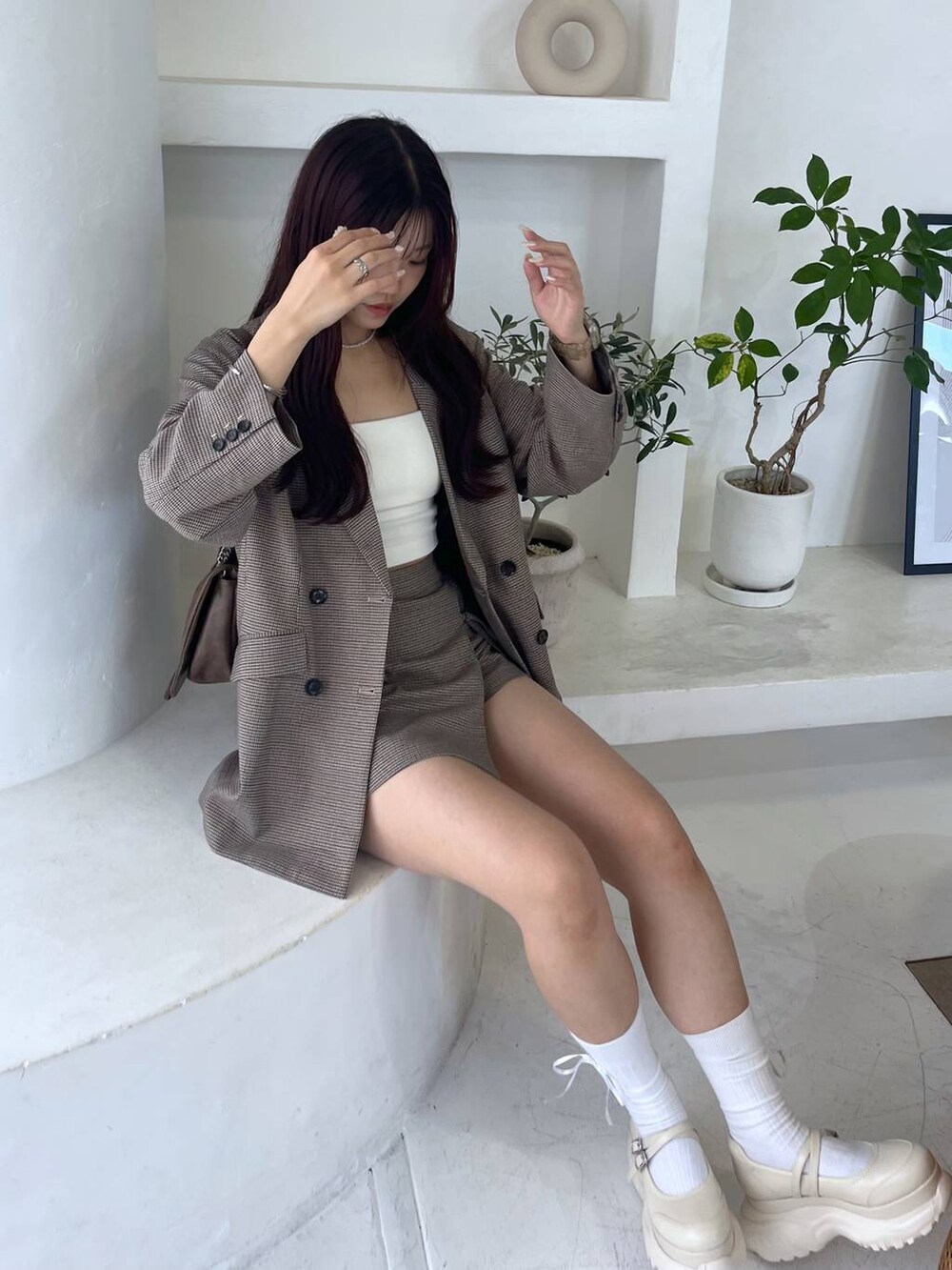 ブラウン系のショルダーバッグ、ホワイト系のキャミソール、ベージュ系のテーラードジャケットを着用したレディースの秋コーディネートの7枚目の写真