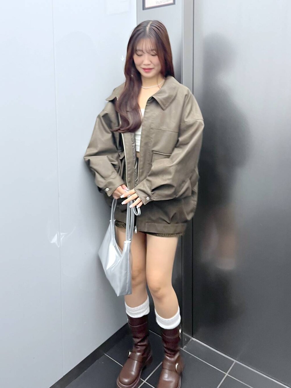 ブラウン系のブーツ、その他のスカート、ホワイト系のキャミソールを着用したレディースの冬コーディネートの3枚目の写真