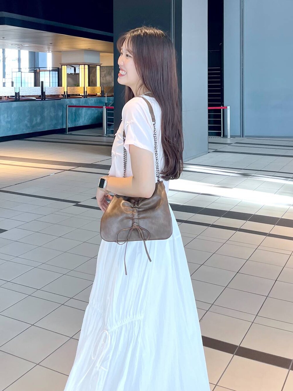 ピンク系のTシャツ/カットソー、ホワイト系のキャミソール、ブラウン系のショルダーバッグを着用したレディースの夏コーディネートの3枚目の写真