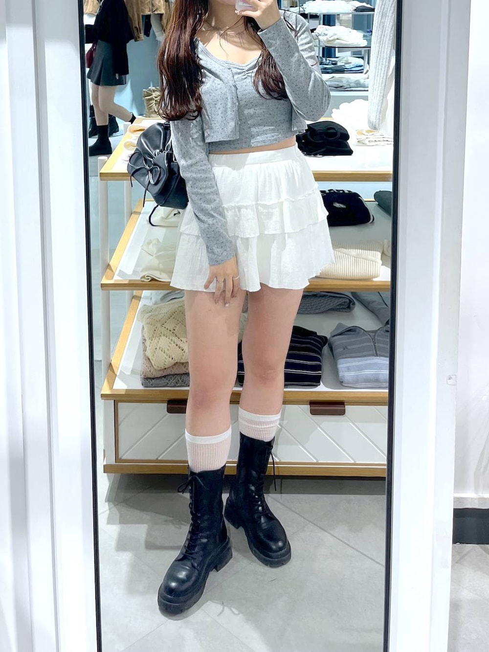 ブラウン系のショルダーバッグ、ホワイト系のキャミソール、ブラック系のブーツを着用したレディースの春コーディネートの3枚目の写真