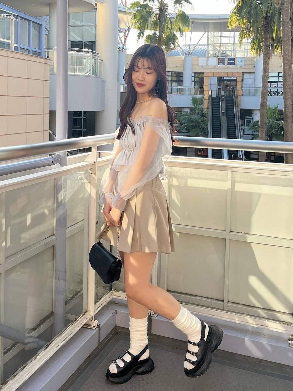 ブラック系のショルダーバッグ、グレー系のシャツ/ブラウス、ホワイト系のキャミソールを着用したレディースの春コーディネートの2枚目の写真