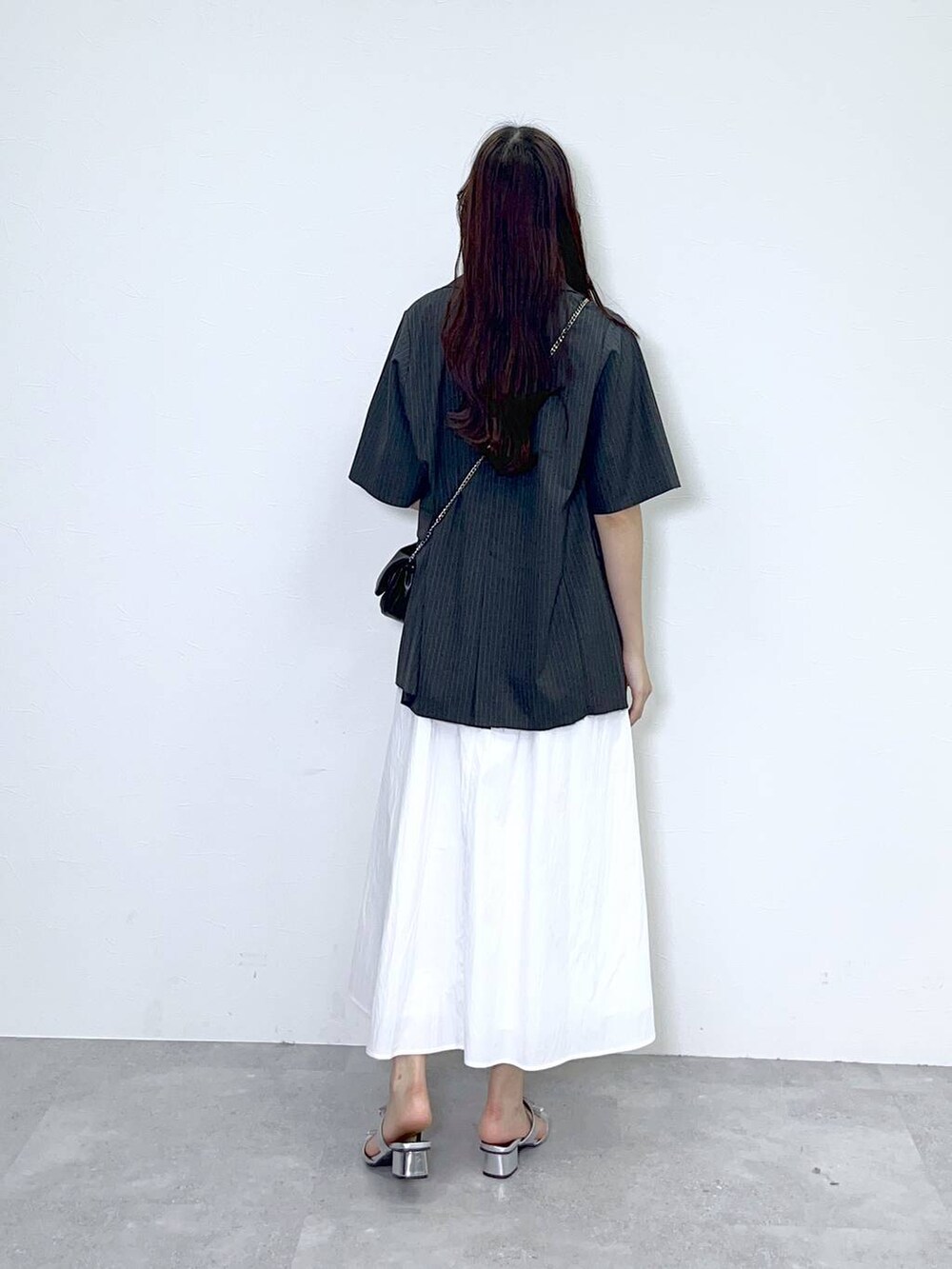 ブラック系のショルダーバッグ、シルバー系のサンダル、ホワイト系のワンピースを着用したレディースの夏コーディネートの4枚目の写真