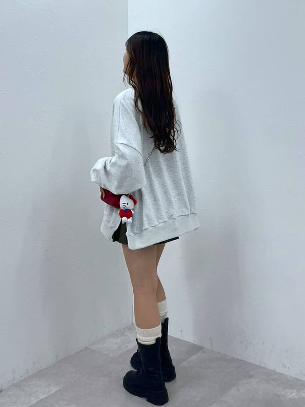 ホワイト系のTシャツ/カットソー、ブラウン系のスカート、レッド系のショルダーバッグを着用したレディースの秋コーディネートの2枚目の写真