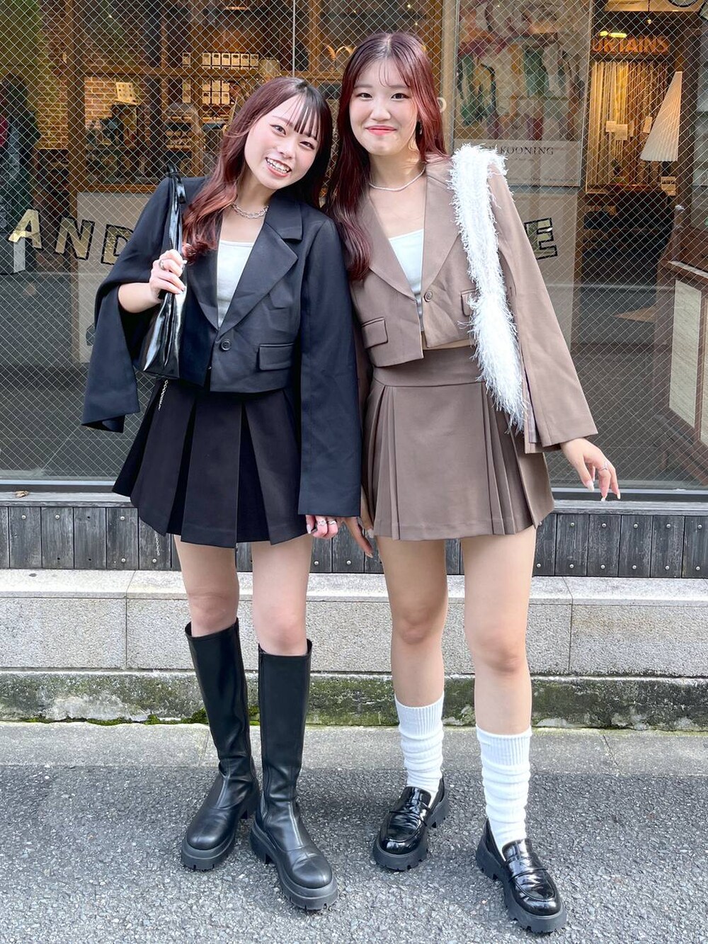 ブラック系のテーラードジャケット、ブラウン系のテーラードジャケット、ブラウン系のスカートを着用したレディースの冬コーディネートの2枚目の写真