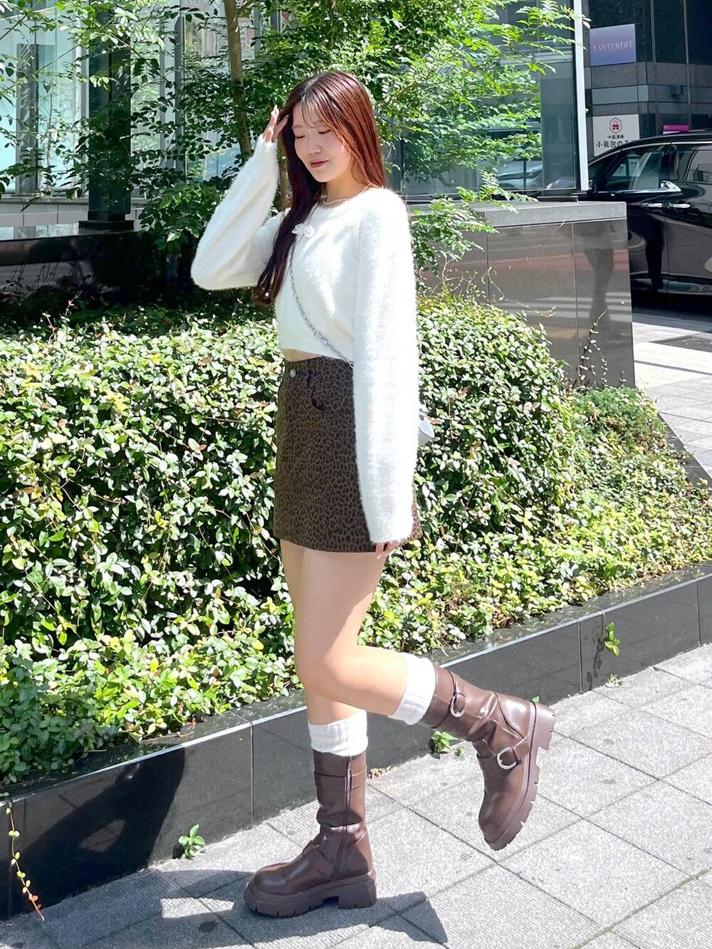 ブラウン系のブーツ、その他のスカート、シルバー系のショルダーバッグを着用したレディースの秋コーディネートの2枚目の写真