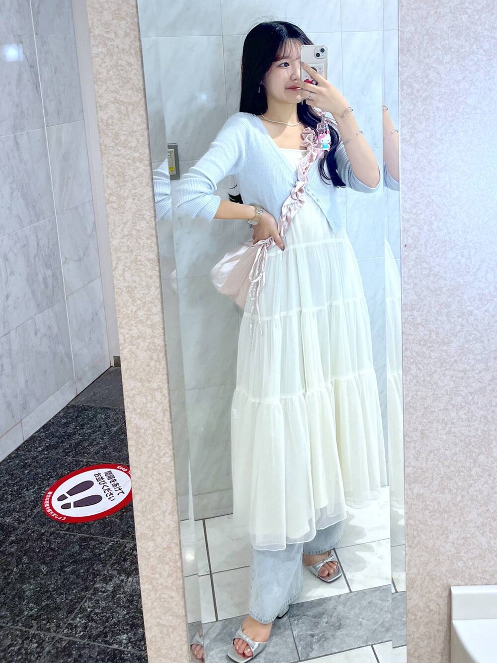 ピンク系のショルダーバッグ、ホワイト系のキャミソール、ブルー系のデニムパンツを着用したレディースの夏コーディネートの5枚目の写真