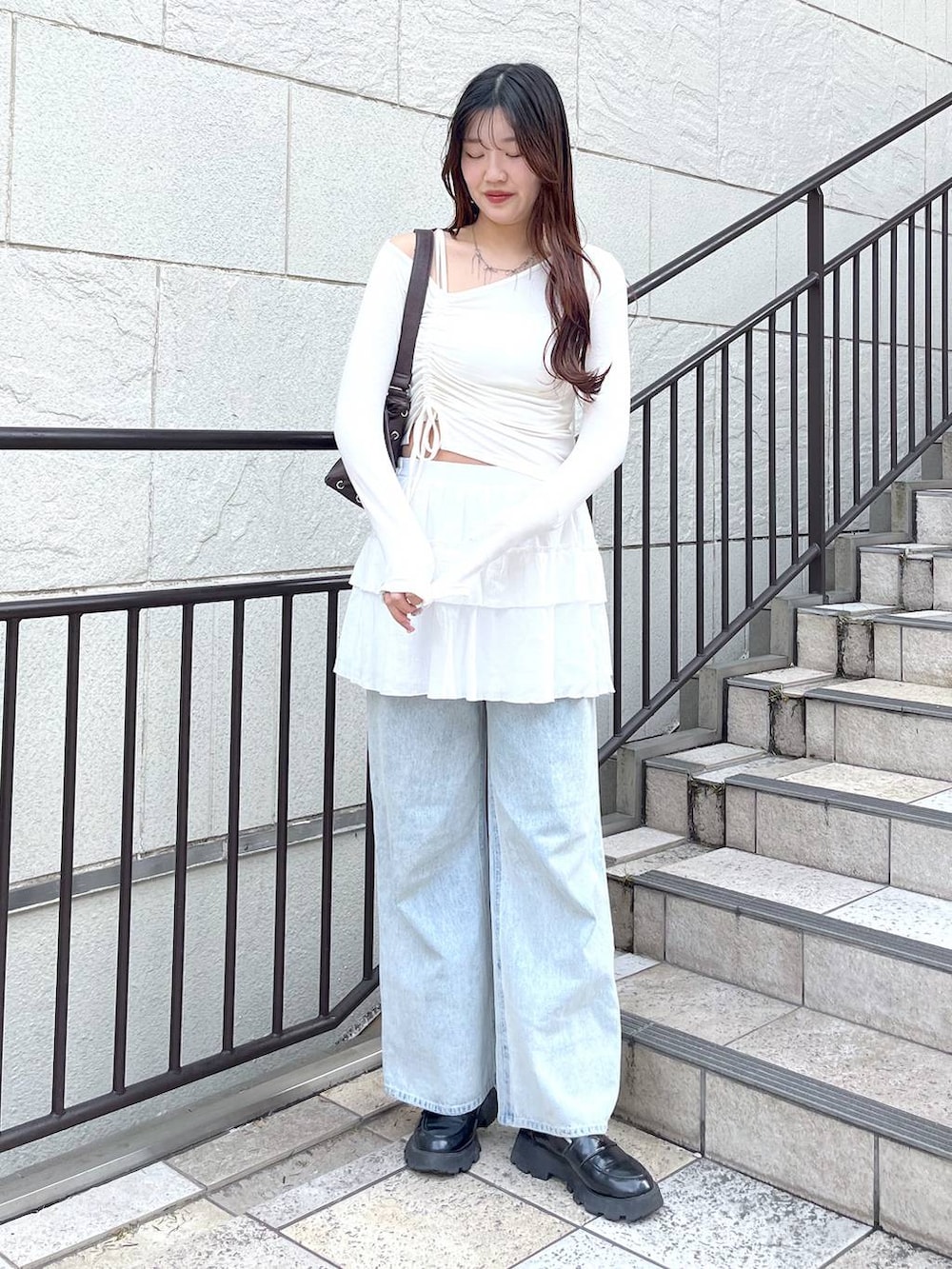 ブルー系のデニムパンツ、ホワイト系のキャミソール、ホワイト系のスカートを着用したレディースの春コーディネートの4枚目の写真