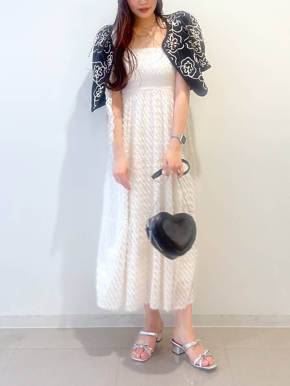 シルバー系のサンダル、ホワイト系のワンピース、ブラック系のショルダーバッグを着用したレディースの春コーディネートの7枚目の写真