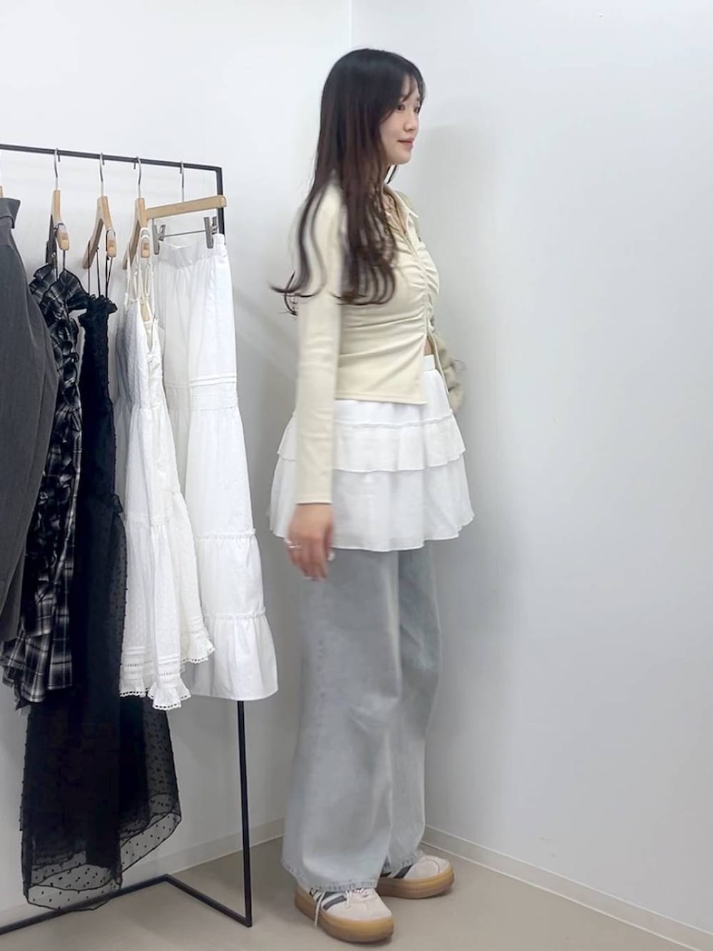 ブルー系のデニムパンツ、ホワイト系のキャミソール、ホワイト系のスカートを着用したレディースの春コーディネートの5枚目の写真