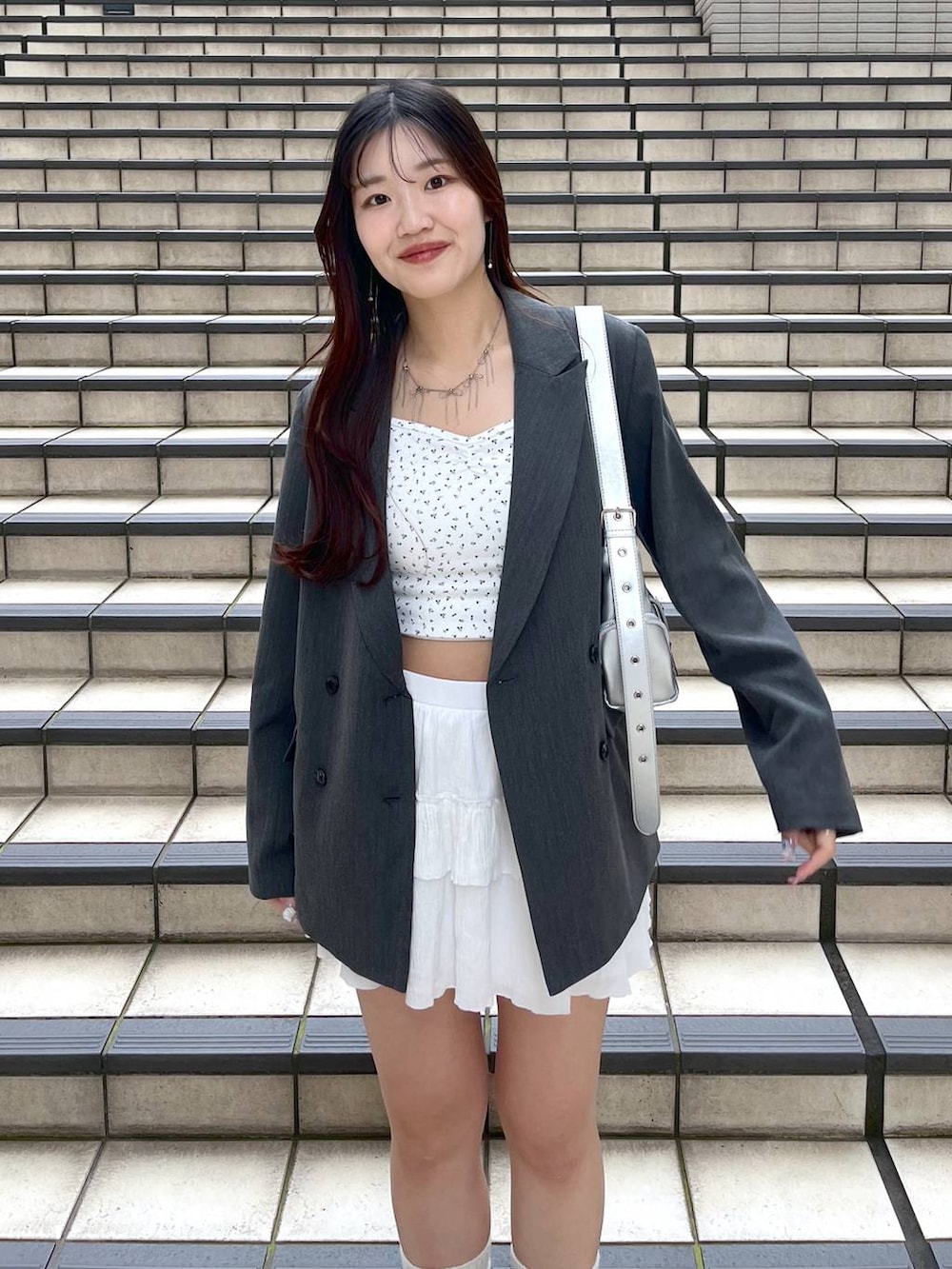 ホワイト系のキャミソール、ホワイト系のスカート、ブラック系のブーツを着用したレディースの春コーディネートの3枚目の写真