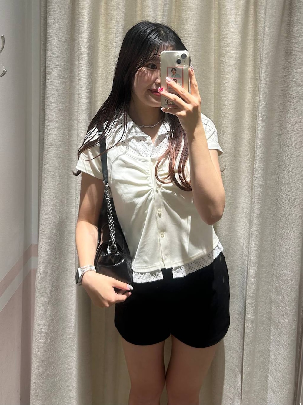 ブラック系のパンプス、ブラック系のショルダーバッグ、ホワイト系のチューブトップを着用したレディースの夏コーディネートの4枚目の写真