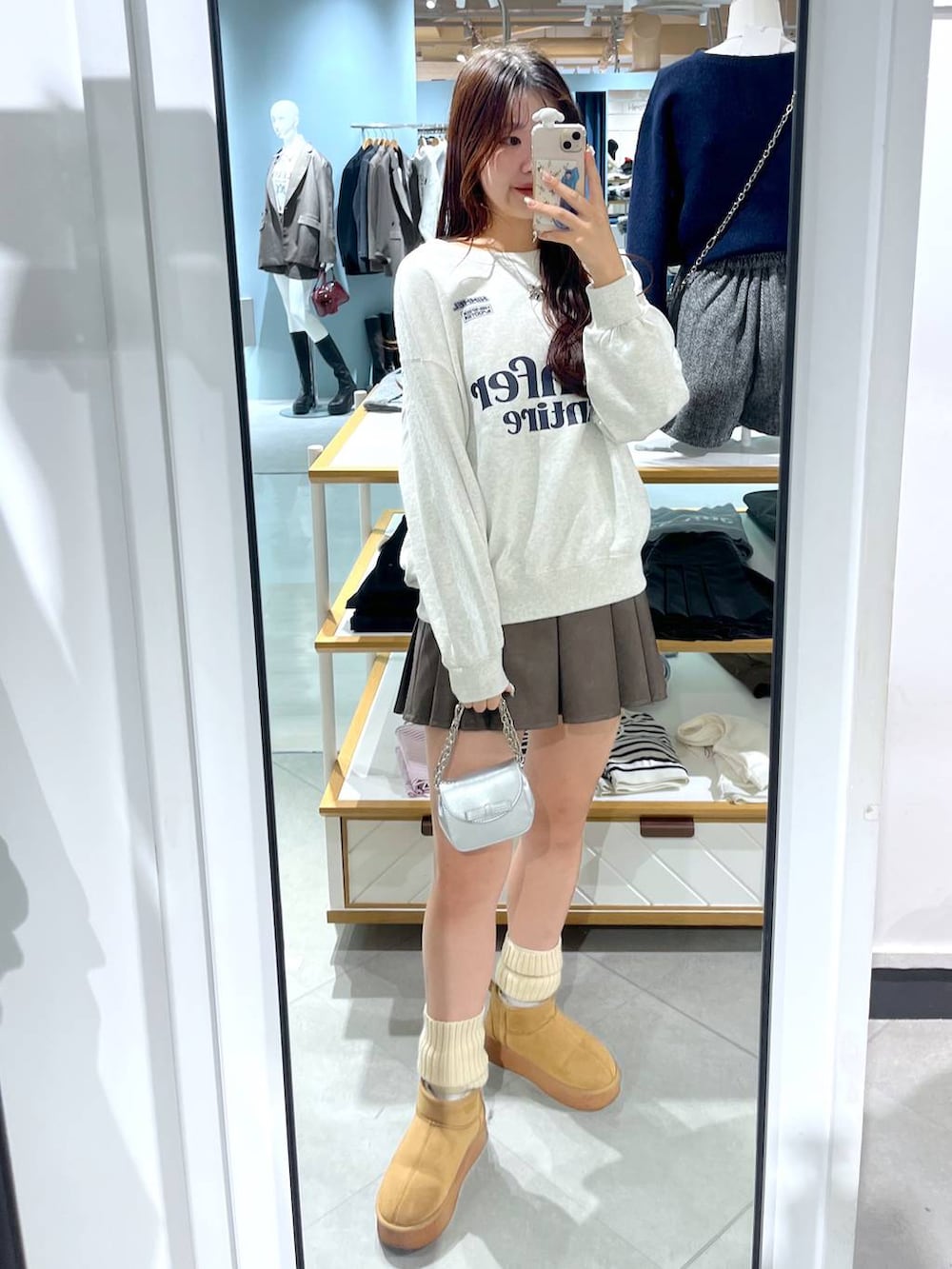 ホワイト系のTシャツ/カットソー、ブラウン系のスカート、ベージュ系のブーツを着用したレディースの冬コーディネートの6枚目の写真